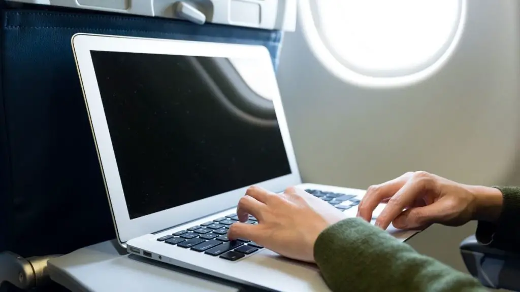 someone with a laptop sitting on a plane 
