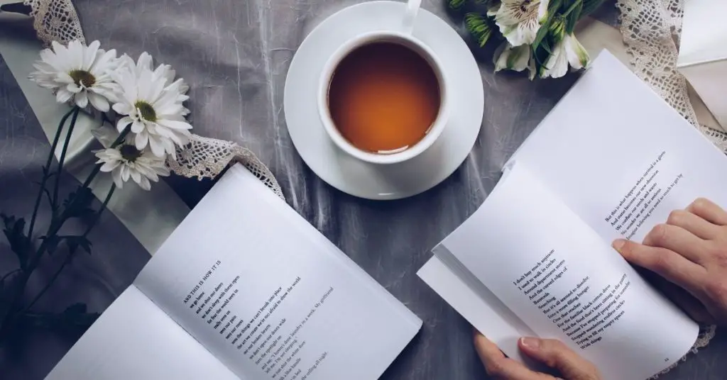 Picture of a cup of tea with someone reading a book