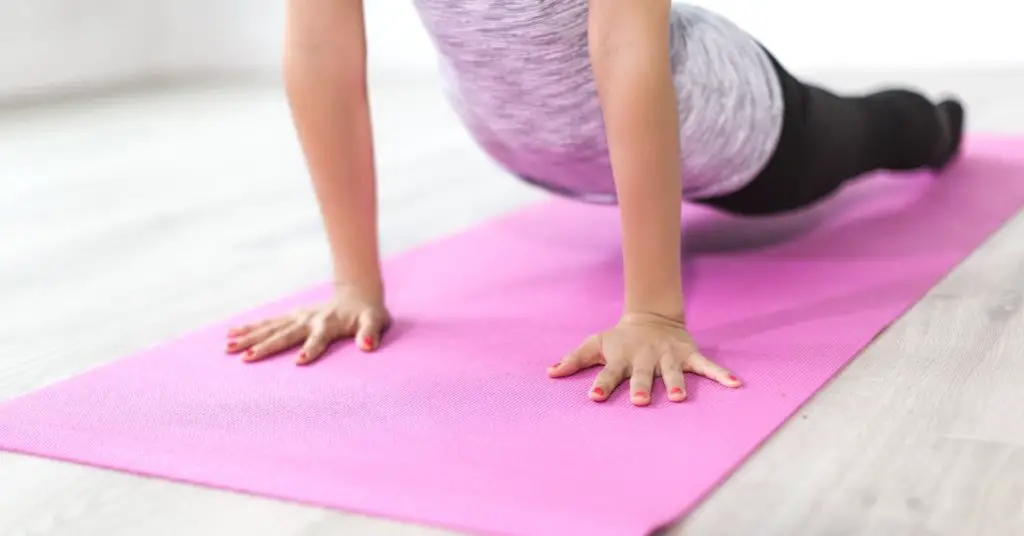 someone doing a plank pose on a yoga mat