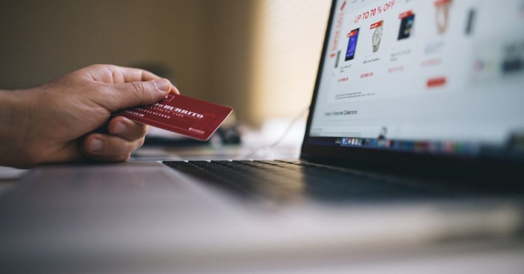 Picture of someone holding a debit card and looking at the computer