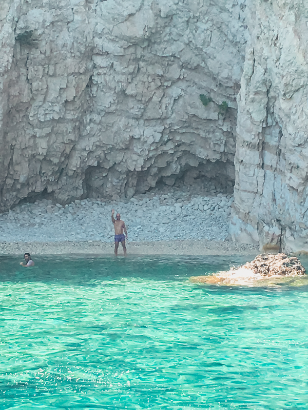 my husband waving from one of the sand coves in the Keri Caves