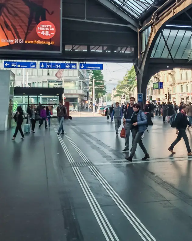 Picture of people walking around inside of the HB Station in Zurich