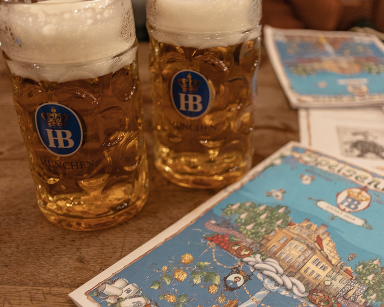 Eating a Hofbräuhaus Brewery must to have a meal with only one day in Munich. Picture of two pints of insanely large beers with menus.