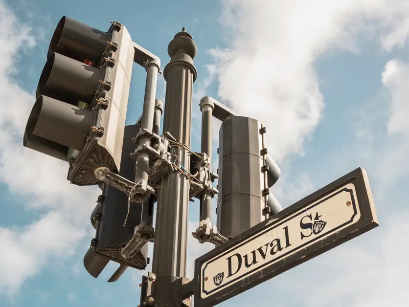 Picture of a stop light with the Duval Street sign. Walking Duval Street is one of the top things to do in Key West.  