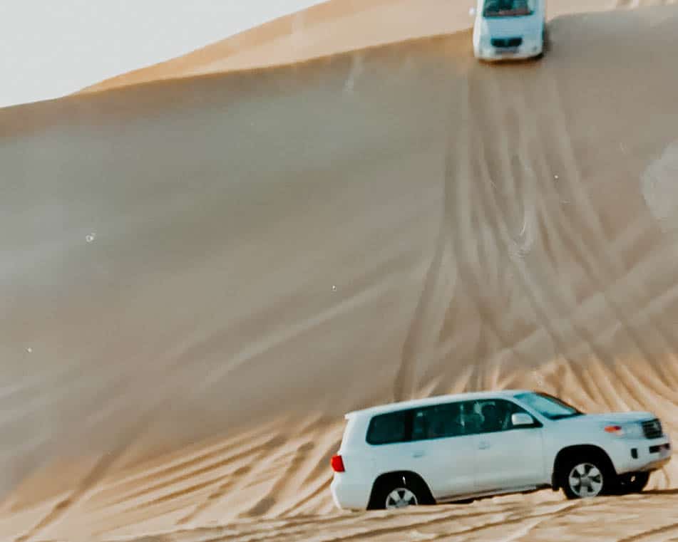 cars going down a sand dune during my Abu Dhabi day trip from Dubai