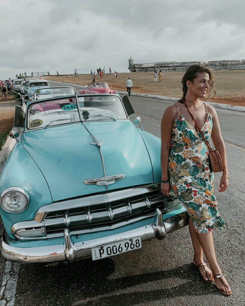 me posing in front of a classic car in havana