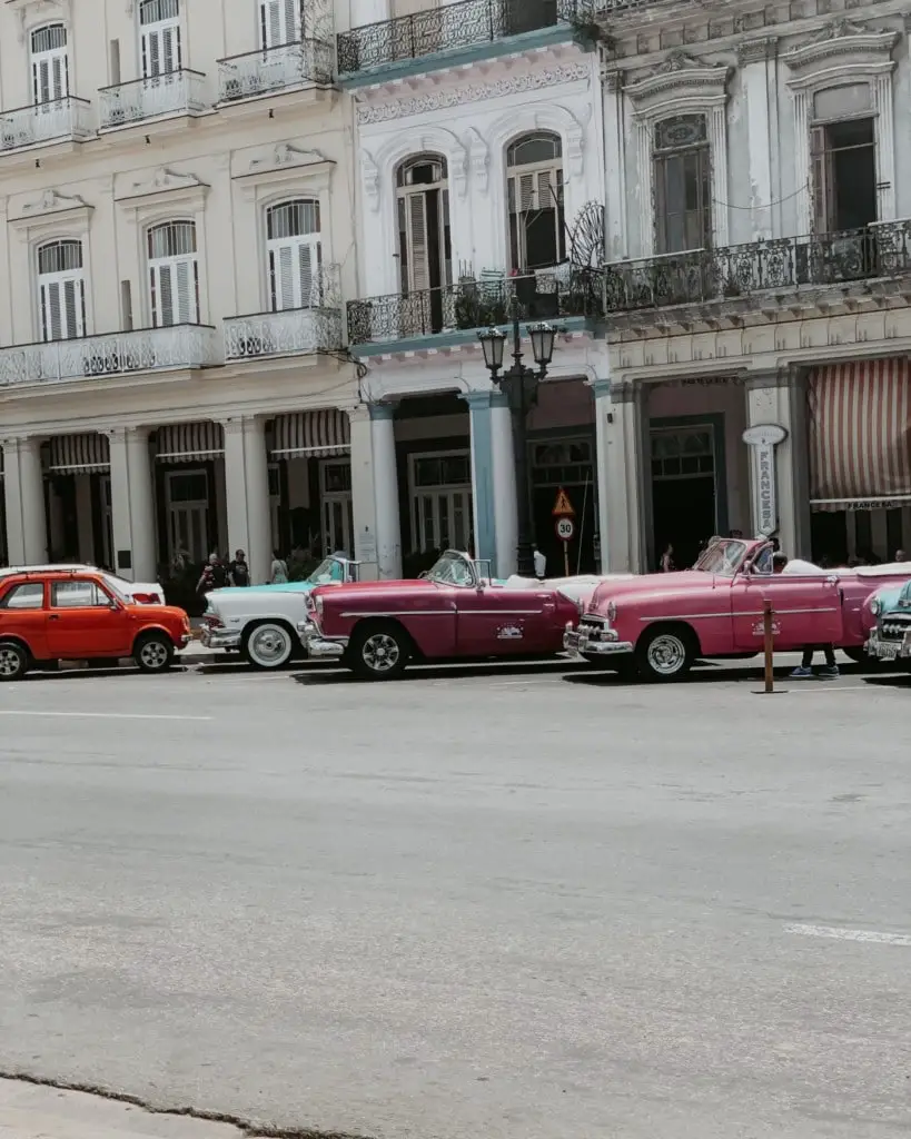 classic cars aligned outside a hotel in Old Havana