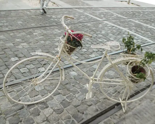 Picture of a bike with potted plants on the winding street in Plaka