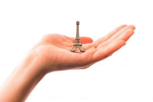 Souvenir Ideas photo of a hand holding a mini figurine of the Eiffel Tower.