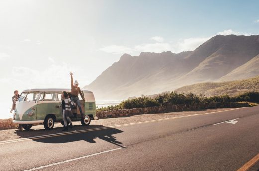 Road trip Instagram caption photos of friends posing by their VW van near the mountains.