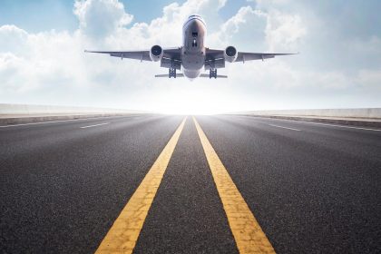 Flying captions photo of an airplane landing on the runway.