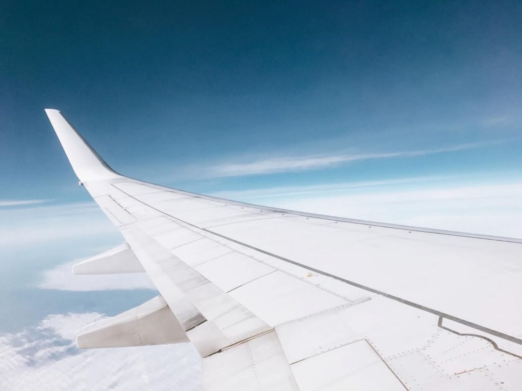 Captions about flying photo of an airplane wing from the window of an airplane. 